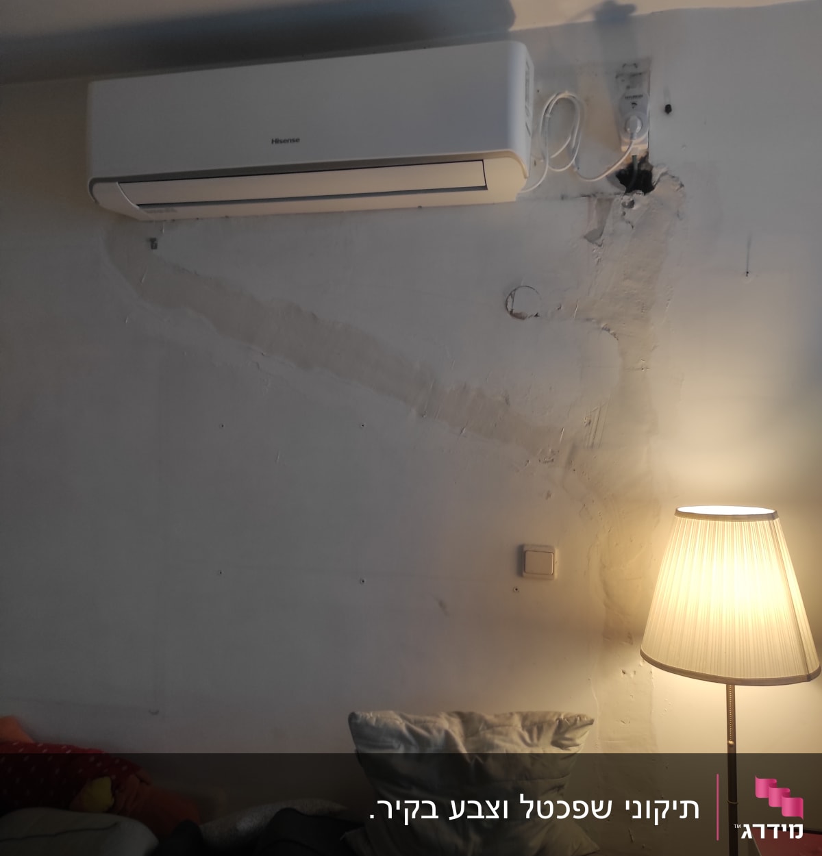 מזגן מותקן על קיר עם חוטי חשמל גלויים